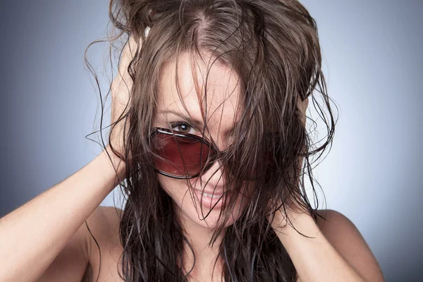 Una mujer divertida gafas de sol con fondo gris —  Fotos de Stock