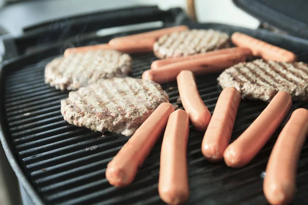 Grilování s hamburgery a hot dog — Stock fotografie