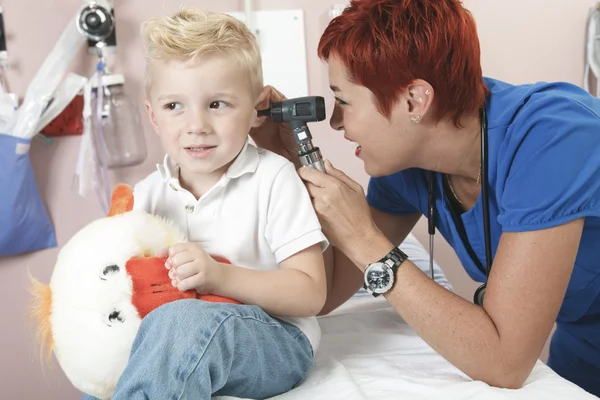 Een arts behandeling van schattige kleine jongen — Stockfoto