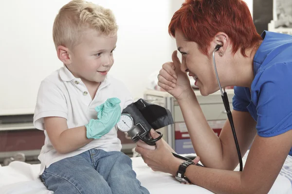 Een arts behandeling van schattige kleine jongen — Stockfoto