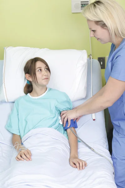 Kleines Mädchen im Krankenhausbett mit der Krankenschwester — Stockfoto