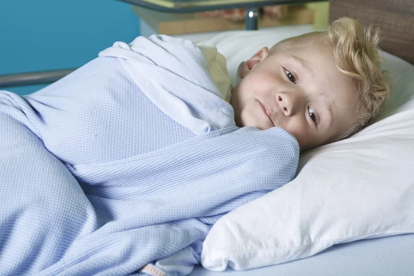 Um menino doente numa cama de hospital — Fotografia de Stock