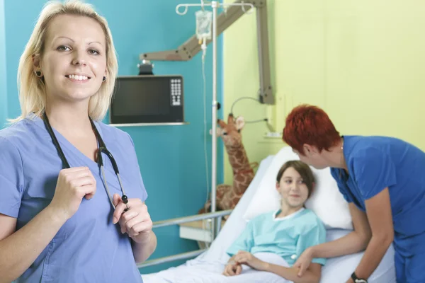 Meisje in ziekenhuisbed met de verpleegkundige — Stockfoto