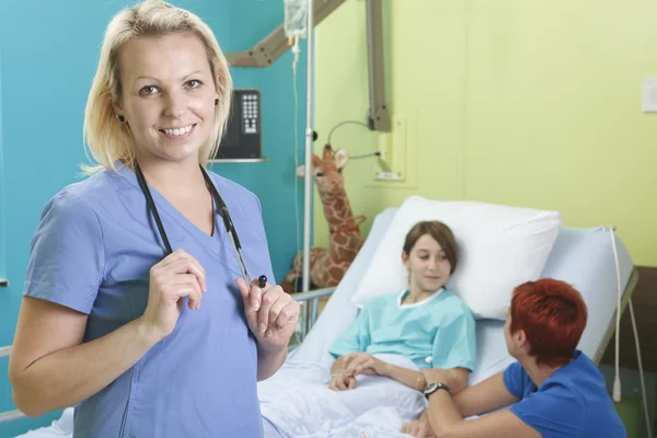 Bambina in ospedale letto con l'infermiera — Foto Stock