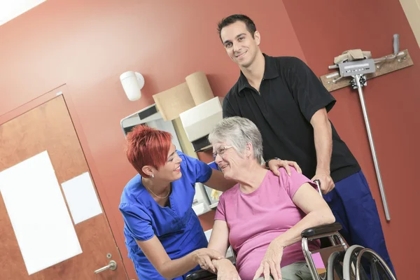 Oudere dame met haar fysiotherapeuten in een ziekenhuis — Stockfoto