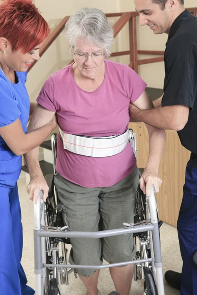 Idosa com seus fisioterapeutas em um hospital — Fotografia de Stock