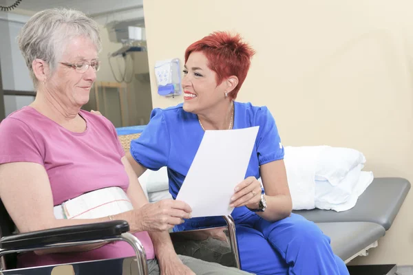 Elderly lady with her physiotherapists in a hospital — Stock Photo, Image