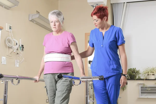 Elderly lady with her physiotherapists in a hospital — Stock Photo, Image