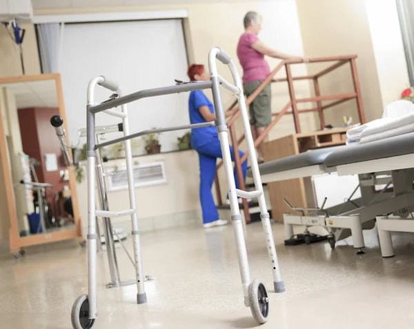 Oudere dame met haar fysiotherapeuten in een ziekenhuis — Stockfoto