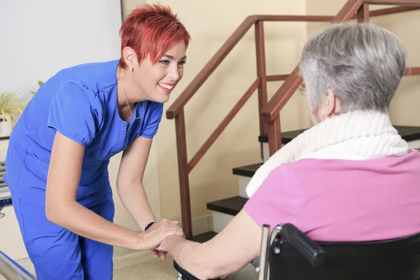 Elderly lady with her physiotherapists in a hospital — Stock Photo, Image