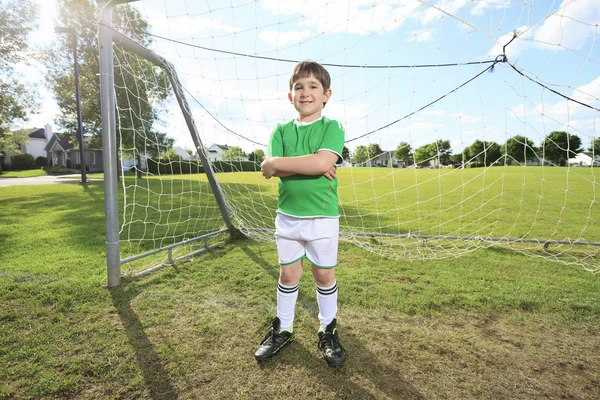 Kid jogar futebol em um campo — Fotografia de Stock