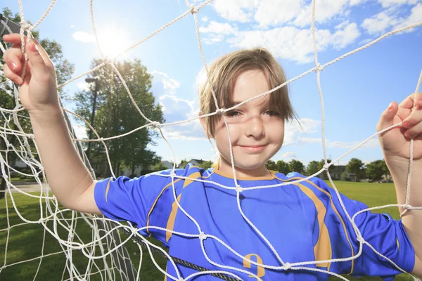 Kid jogar futebol em um campo — Fotografia de Stock