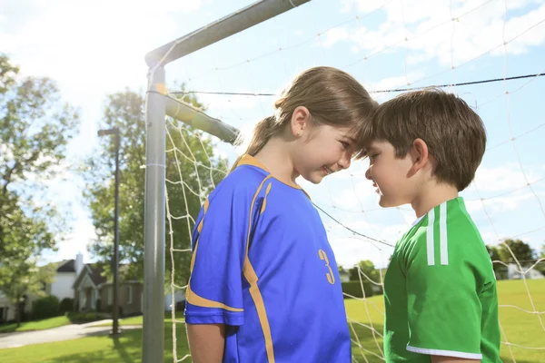 Dos niños juegan al fútbol en un campo — Foto de Stock