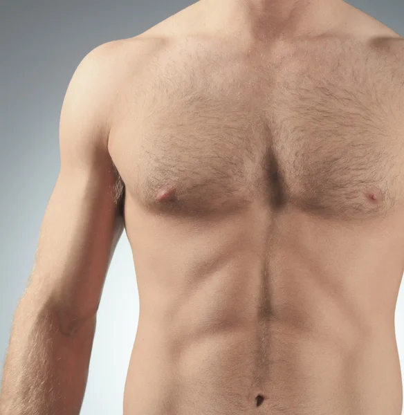 Close-up healthy muscular young man on a gray background — Stock Photo, Image