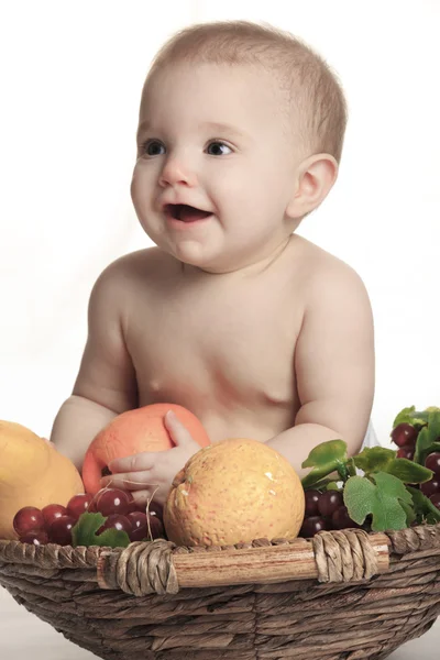 Happy little baby girl with fruits on the basket — Stock Photo, Image
