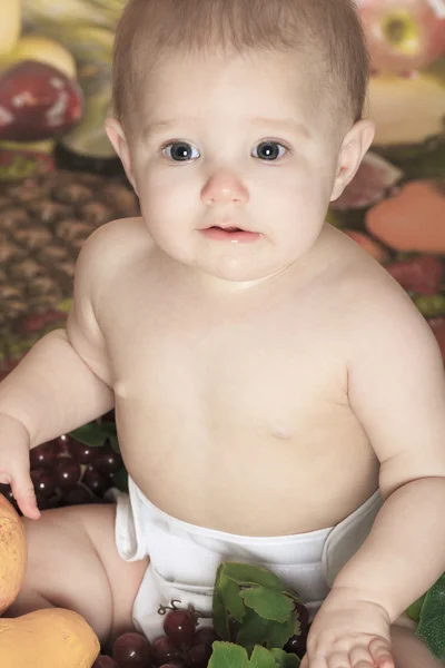 Happy little baby girl with fruits on the basket — Stock Photo, Image