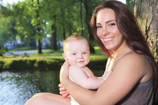 Una madre con su bebé en un hermoso bosque — Foto de Stock