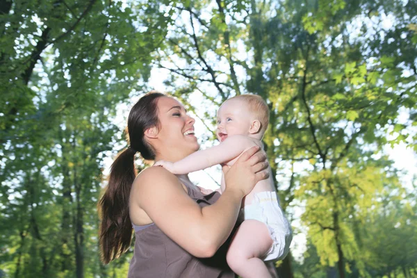 Eine Mutter mit ihrem Baby in einem schönen Wald — Stockfoto