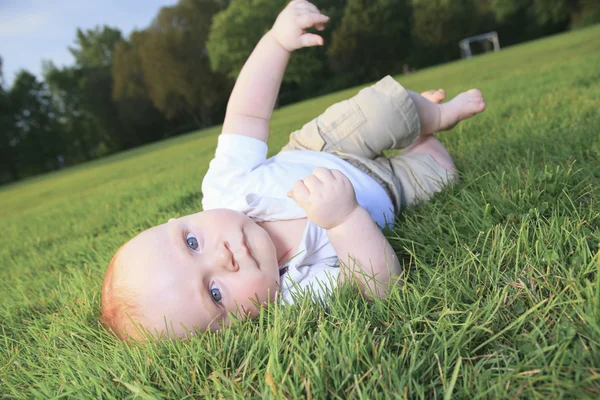 Little boy play in green grass — Stock Photo, Image