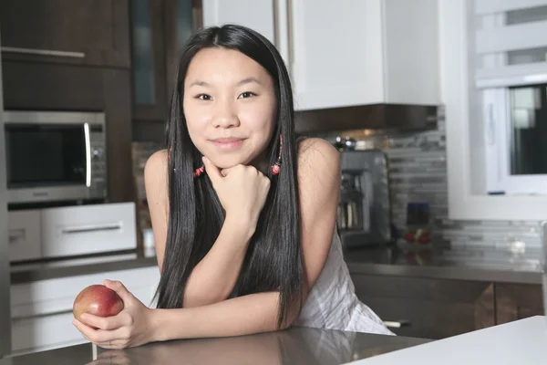 台所で apple と 10 代の少女の笑顔の肖像画 — ストック写真