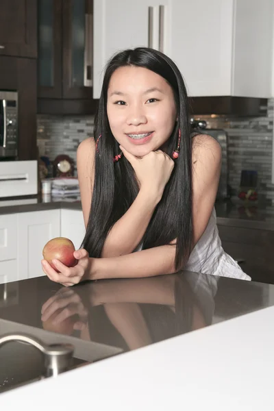 台所で apple と 10 代の少女の笑顔の肖像画 — ストック写真