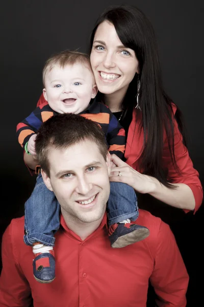Lycklig familj, far, mor och barn framför en svart tillbaka — Stockfoto