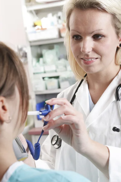 Happy little girl at the doctor for a checkup - being examined w Stock Photo