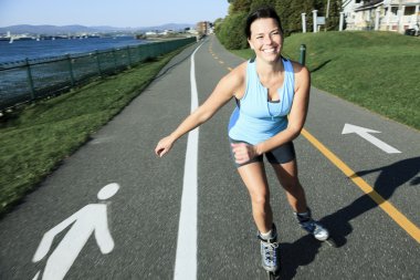 A woman with is rollerblade in summer time clipart