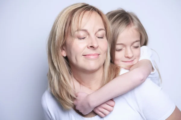 Een moeder met is dochter over grijze achtergrond — Stockfoto