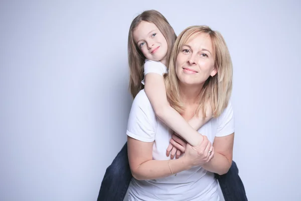 Een moeder met is dochter over grijze achtergrond — Stockfoto