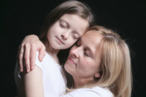 Eine Mutter mit ihrer Tochter vor dunklem Hintergrund — Stockfoto