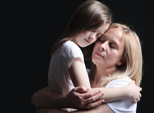 Een moeder met is dochter over donkere achtergrond — Stockfoto