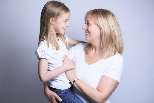 Uma mãe com é filha sobre fundo cinza — Fotografia de Stock