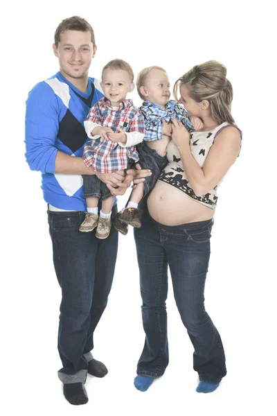Família jovem com mãe grávida posando em estúdio no backgro branco — Fotografia de Stock