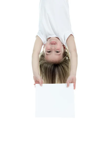 Una niña sosteniendo una tarjeta blanca sobre un fondo blanco . — Foto de Stock