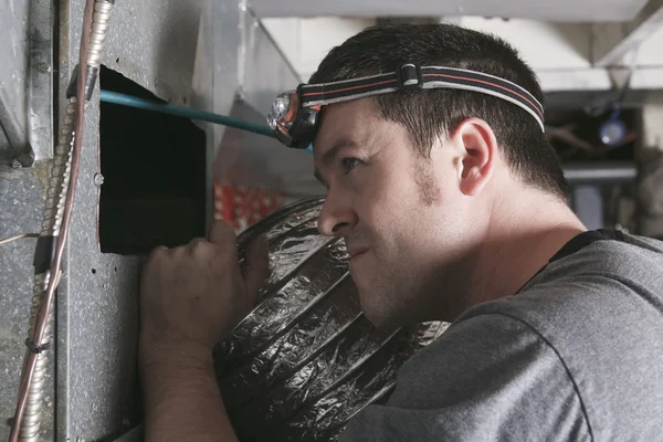 Een man ventilatie schonere op het werk met gereedschap — Stockfoto