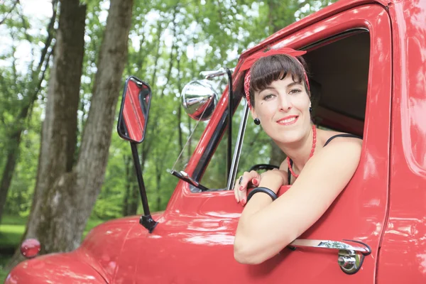 A retro girl with a beautiful red old car.