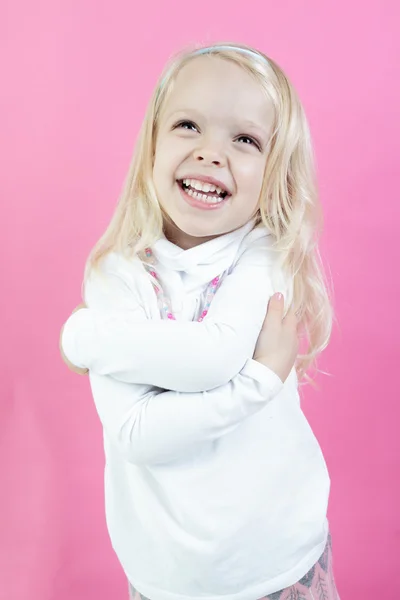 Маленькая блондинка, изолированная на розовом фоне — стоковое фото