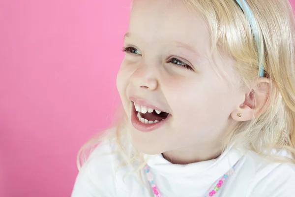 Een blond meisje geïsoleerd op roze achtergrond — Stockfoto