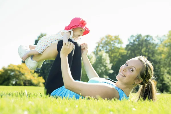Uma mãe treinando com bebê em um dia de verão — Fotografia de Stock