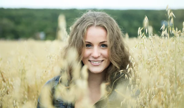 Een mooie jonge vrouw portret in hooi veld. — Stockfoto