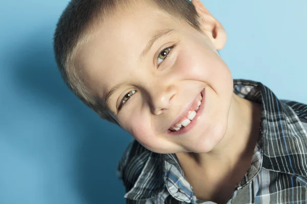 Um menino com um fundo azul atrás — Fotografia de Stock