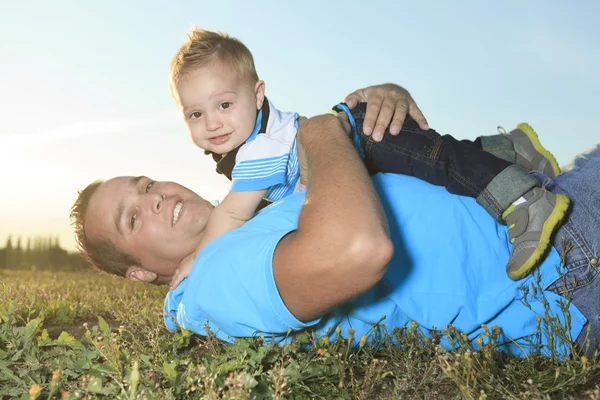 En pappa med är son på solnedgången — Stockfoto