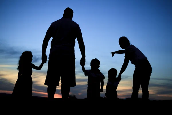 Silhouet van een jong gezin met sommige childs permanent — Stockfoto