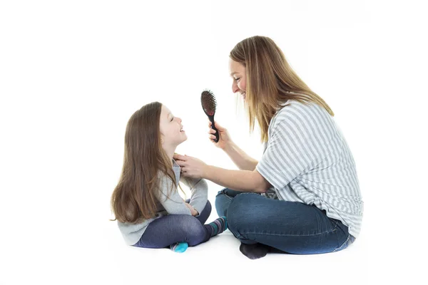 Mãe jovem bonita feliz com sua filha pouco alegre - isolado em branco — Fotografia de Stock