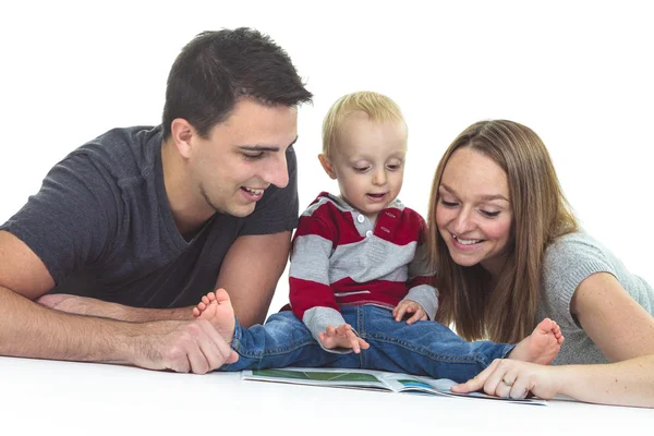 Mère, père et bébé souriants lisant ensemble le livre sur fond blanc isolé — Photo