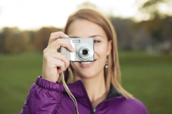 Porträt einer jungen, charmanten Frau, die eine Fotokamera hält und — Stockfoto