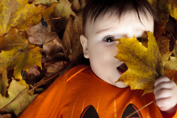 Zoete lachen meisje van de baby spelen met een enorme pompoen dragen van een gebreide pompoen hoed op witte achtergrond — Stockfoto