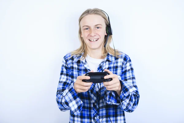 A teen boy playing video games against gray background — Stock Photo, Image