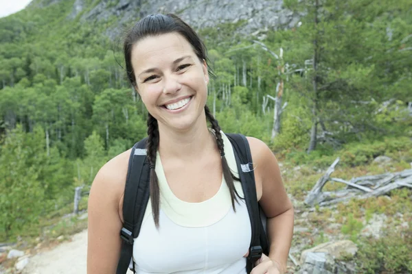 Female hiker with backpack walking and smiling on a country trai — Stock Photo, Image